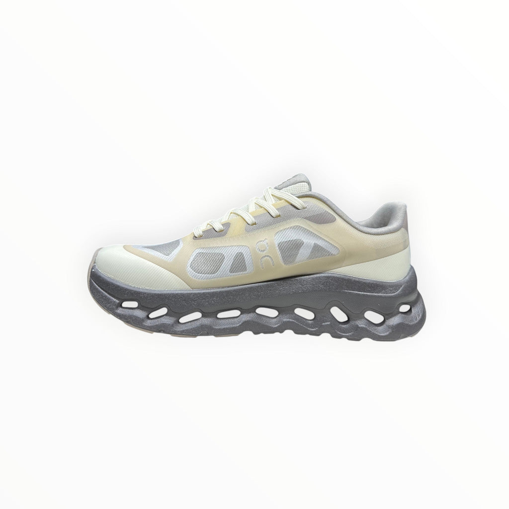 EWW Sports Shoes On Cloudtilt Remix grey and yellow running shoes with see-through upper and chunky grey sole.