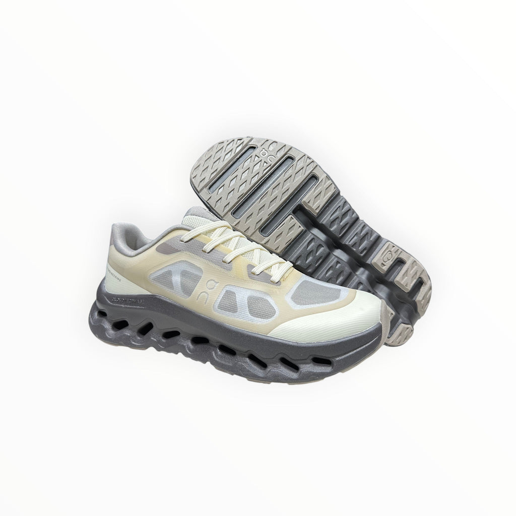 EWW Sports Shoes On Cloudtilt Remix grey and yellow running shoes with a see-through upper and chunky sole.