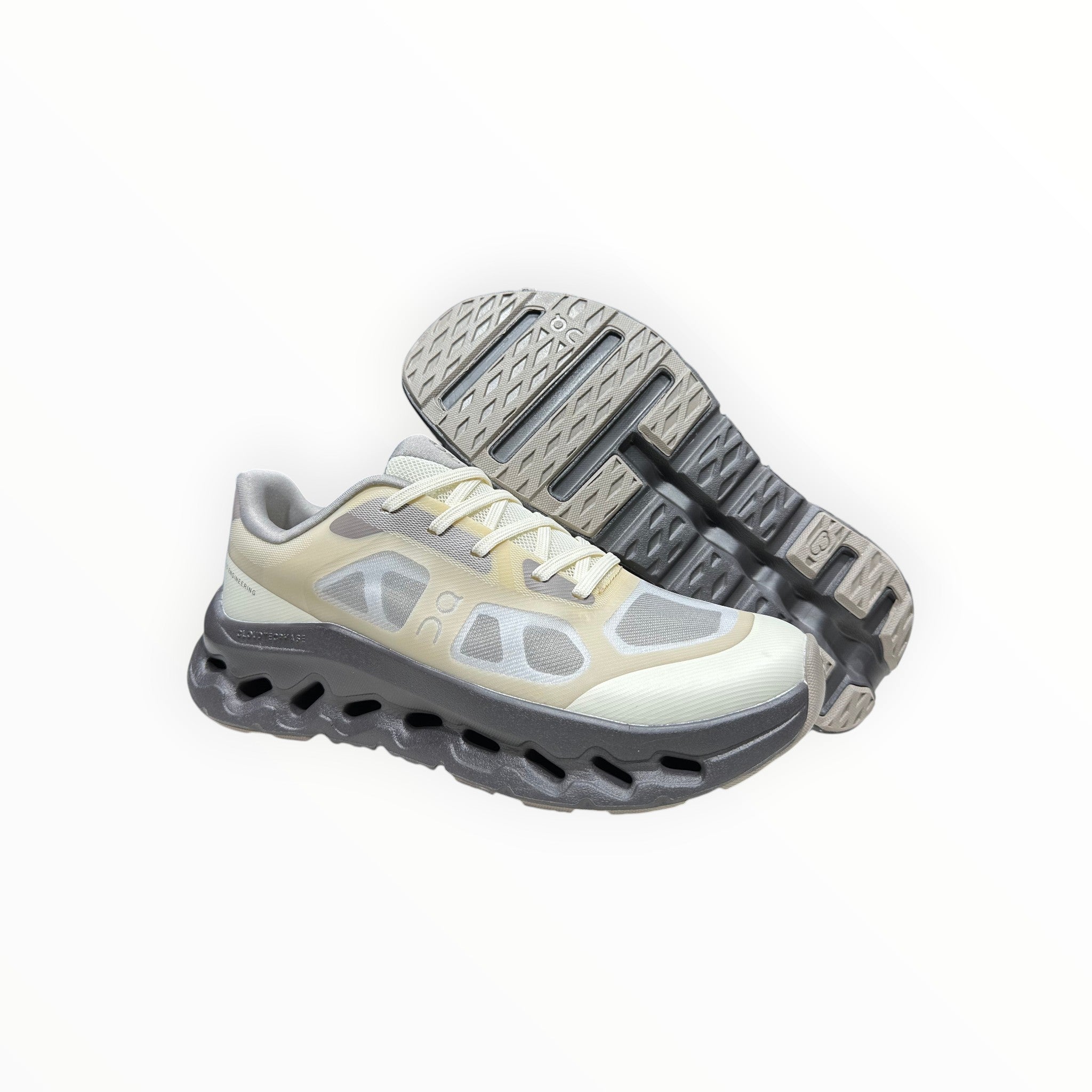 EWW Sports Shoes On Cloudtilt Remix grey and yellow running shoes with a see-through upper and chunky sole.